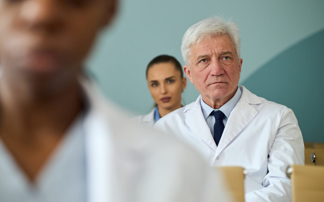 Medical experts attending a professional case review meeting while taking notes and analyzing documentation.